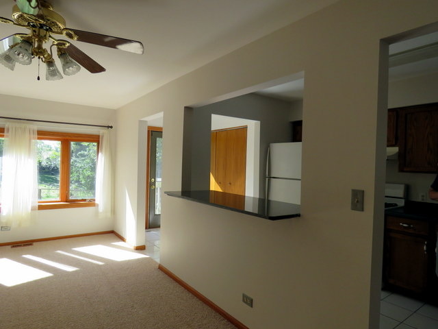 304 Ralph Court Island Lake, IL 60042 - Photo 6 of 16 a view of an empty room with a window and wooden floor