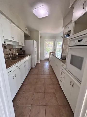 a large white kitchen with cabinets