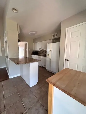 a kitchen with stainless steel appliances granite countertop a refrigerator and a stove