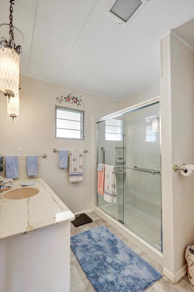 287 Robin Lane Oceanside, CA 92057 - Photo 16 of 27 a bathroom with a granite countertop sink a toilet and shower
