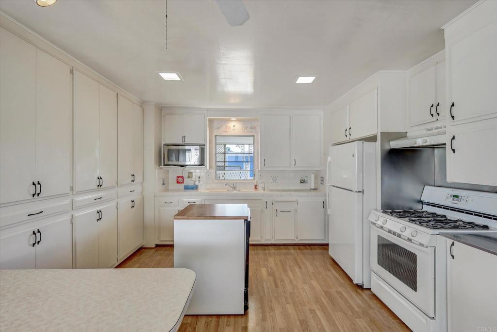 287 Robin Lane Oceanside, CA 92057 - Photo 4 of 27 a kitchen with white cabinets and stainless steel appliances