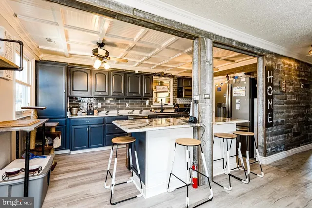 a kitchen with stainless steel appliances kitchen island granite countertop a table chairs stove and a sink