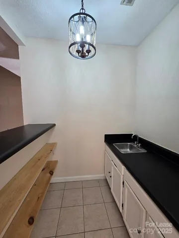 an empty room with wooden floor fireplace and windows