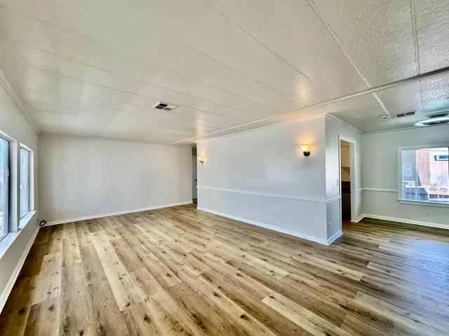 a view of empty room with wooden floor