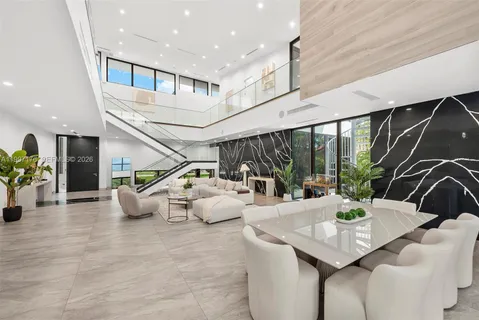 a living room with large windows and a table
