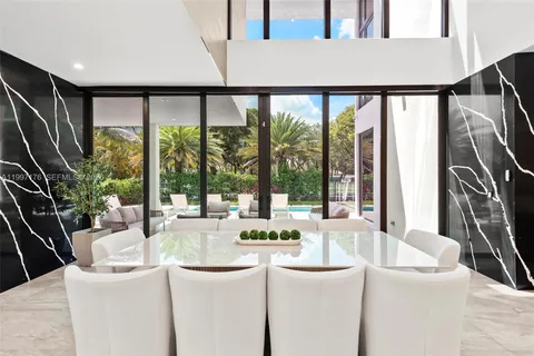 a living room with stainless steel appliances granite countertop a sink a counter top space and furniture