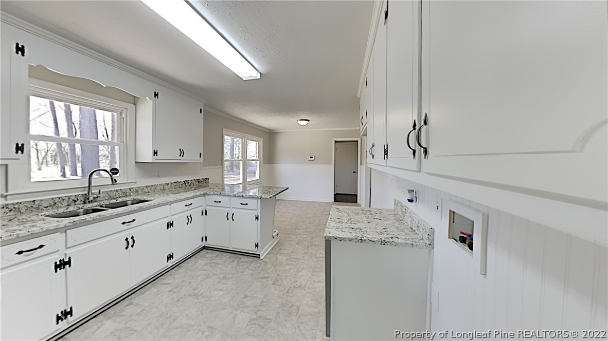 2753 Wade-Stedman Road Stedman, NC 28391 - Photo 4 of 15 a large white kitchen with granite countertop a sink white cabinets and a granite counter tops