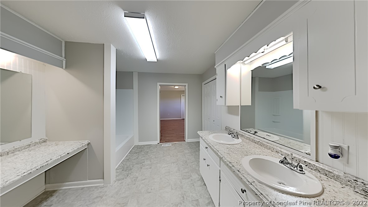 2753 Wade-Stedman Road Stedman, NC 28391 - Photo 8 of 15 a bathroom with a granite countertop sink and a mirror