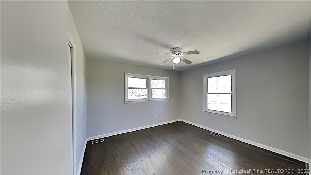 2753 Wade-Stedman Road Stedman, NC 28391 - Photo 10 of 15 an empty room with wooden floor chandelier fan and windows