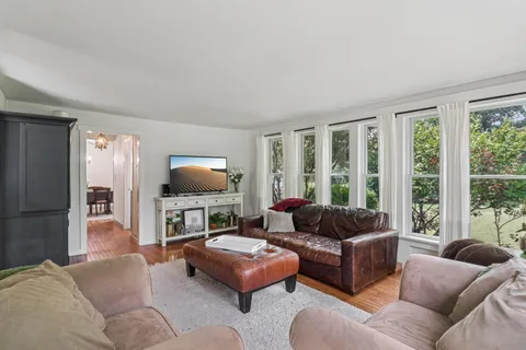 a dining room with furniture a chandelier and wooden floor