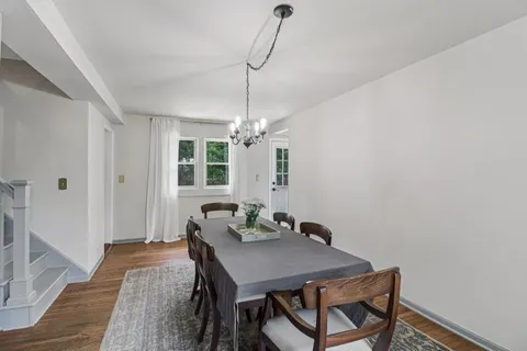 a dining room with wooden floor and windows