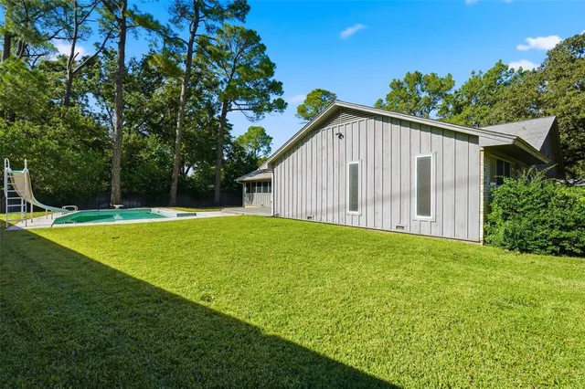 an aerial view of a houses with a yard and lake view