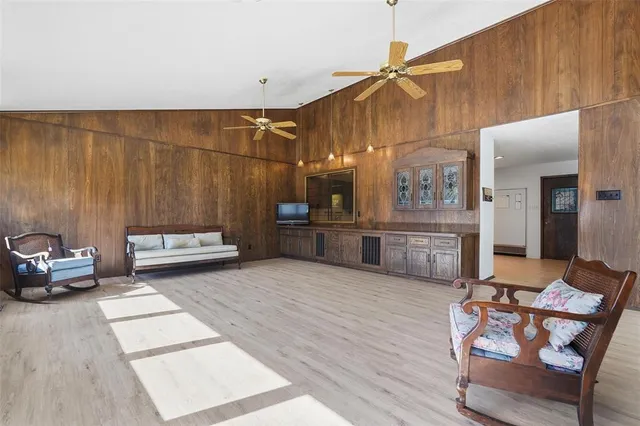 a living room with couches and kitchen view with wooden floor