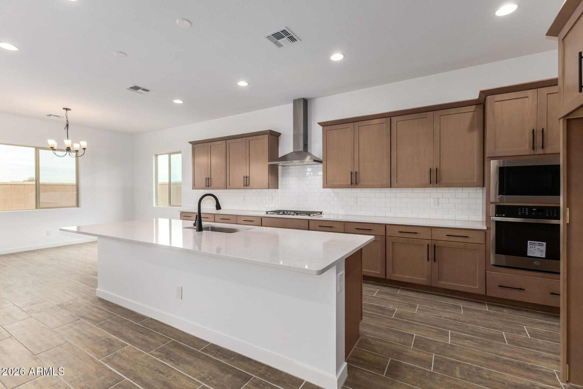 18146 West Watkins Street Goodyear, AZ 85338 - Photo 3 of 36 a kitchen with kitchen island granite countertop a sink stove and cabinets