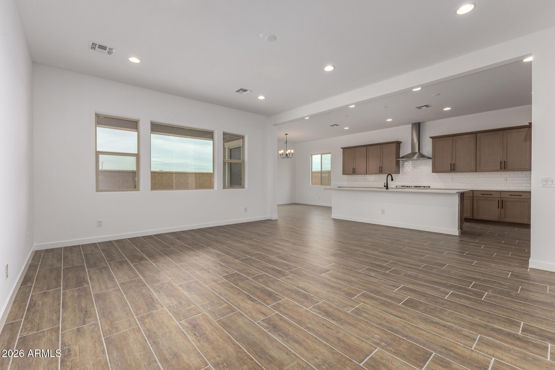 18146 West Watkins Street Goodyear, AZ 85338 - Photo 7 of 36 a view of a kitchen with kitchen island a sink wooden floor and stainless steel appliances