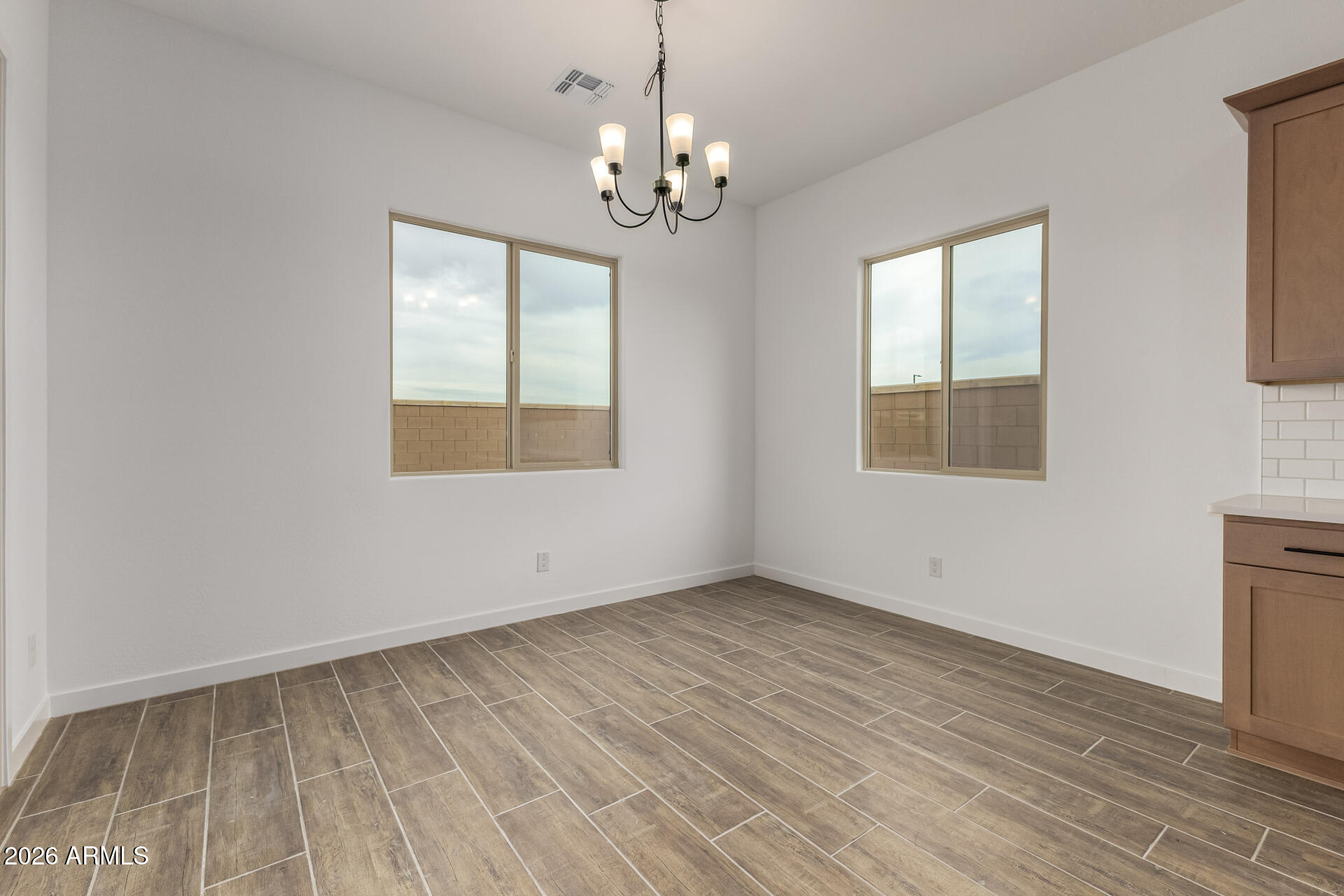 18146 West Watkins Street Goodyear, AZ 85338 - Photo 9 of 36 a view of an empty room with wooden floor and a window