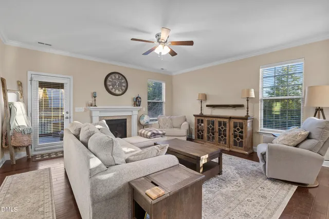 a living room with furniture a clock and a fireplace