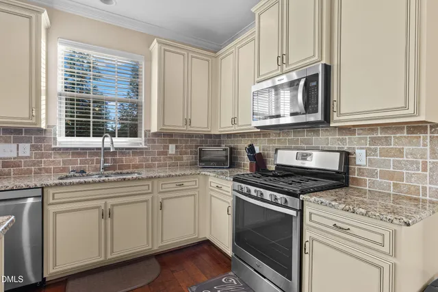 a kitchen with granite countertop white cabinets and sink