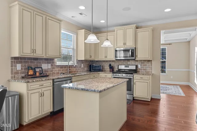 a kitchen with stainless steel appliances granite countertop wooden cabinets granite counter tops and a hard wood floors