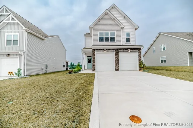a view of a big house with wooden fence