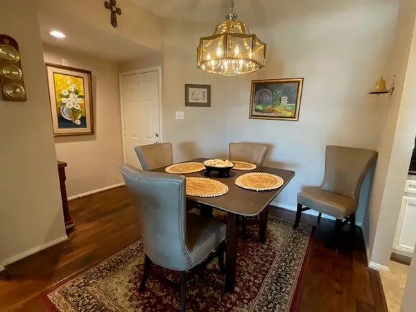 a view of a dining room with furniture a chandelier and wooden floor
