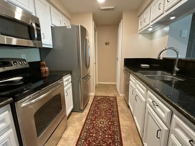 a kitchen with stainless steel appliances a refrigerator sink and microwave