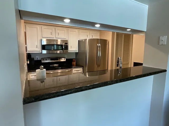 a kitchen with granite countertop a sink and cabinets