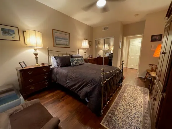 a bedroom with a bed rug and wooden floor