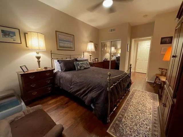 a bedroom with a bed rug and wooden floor