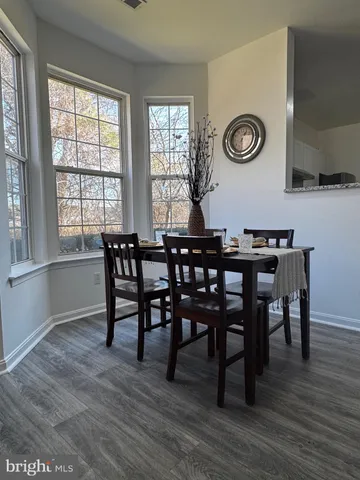 a view of a dining room and livingroom with furniture wooden floor and a clock