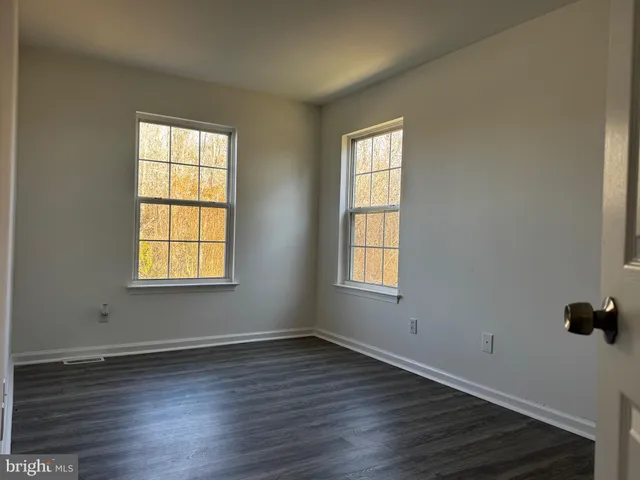a view of a hallway with wooden floor and closet area