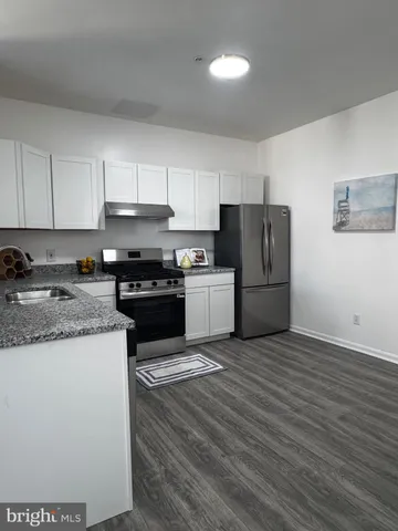 a kitchen with a refrigerator stove top oven and sink