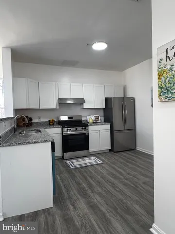 a kitchen with a sink a stove top oven and white stainless steel appliances
