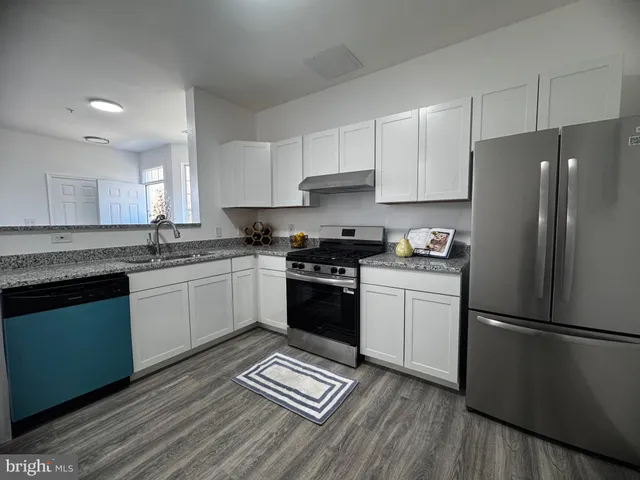 a kitchen with a refrigerator stove top oven and cabinets
