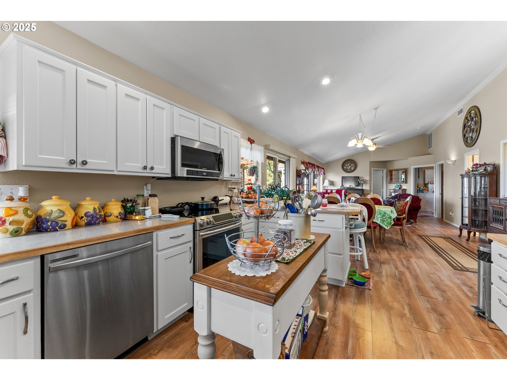 838 Marina Heights Road Brookings, OR 97415 - Photo 25 of 47 a kitchen with stainless steel appliances kitchen island granite countertop a stove top oven a sink dishwasher and white cabinets with wooden floor