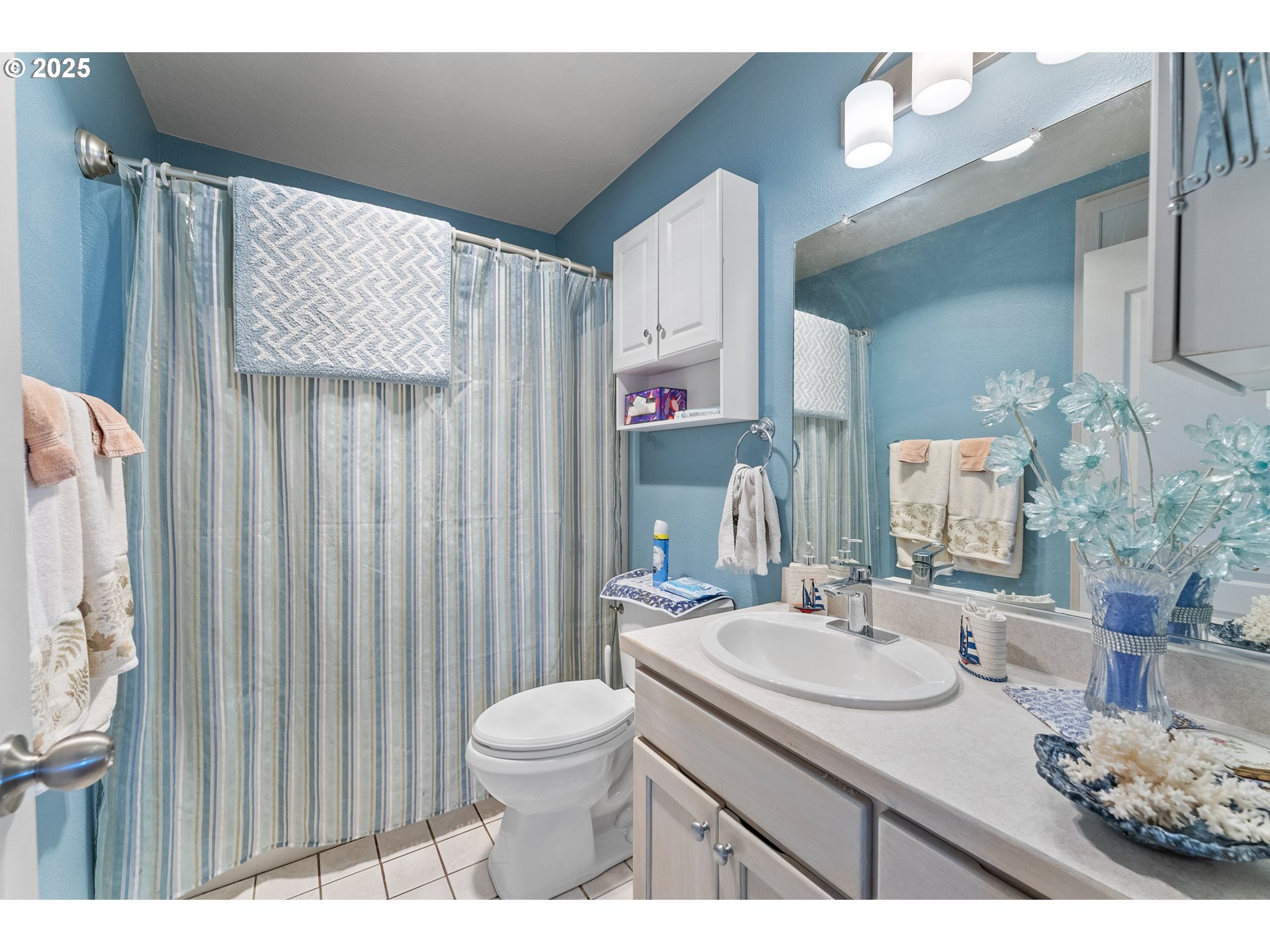 838 Marina Heights Road Brookings, OR 97415 - Photo 38 of 47 a bathroom with a sink a toilet and shower curtain