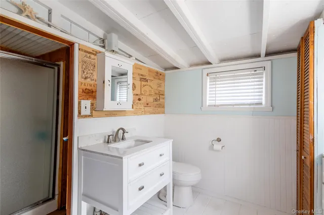 a bathroom with a sink toilet a mirror and shower