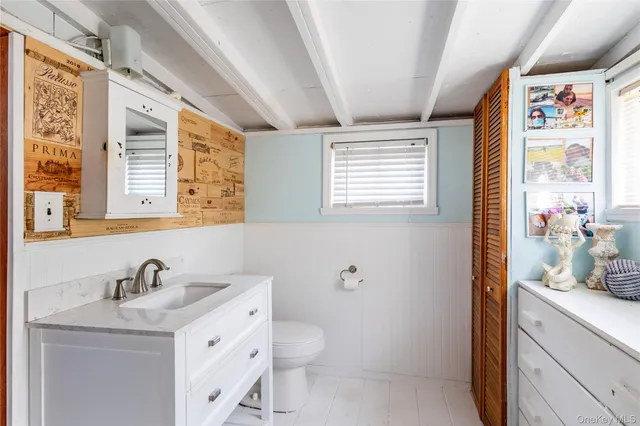 a bathroom with a granite countertop sink toilet and a large mirror