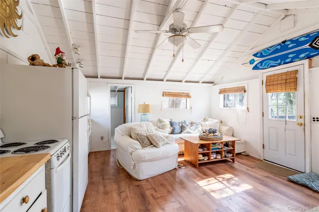 a living room with furniture and a dining table with wooden floor