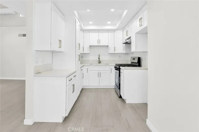 a kitchen with white cabinets stainless steel appliances and sink