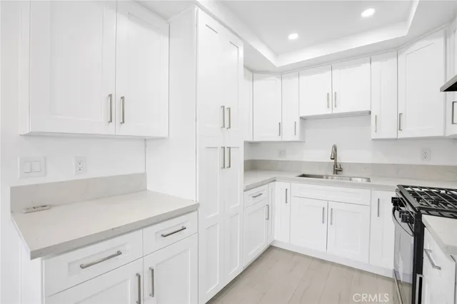 a kitchen with white cabinets appliances and sink