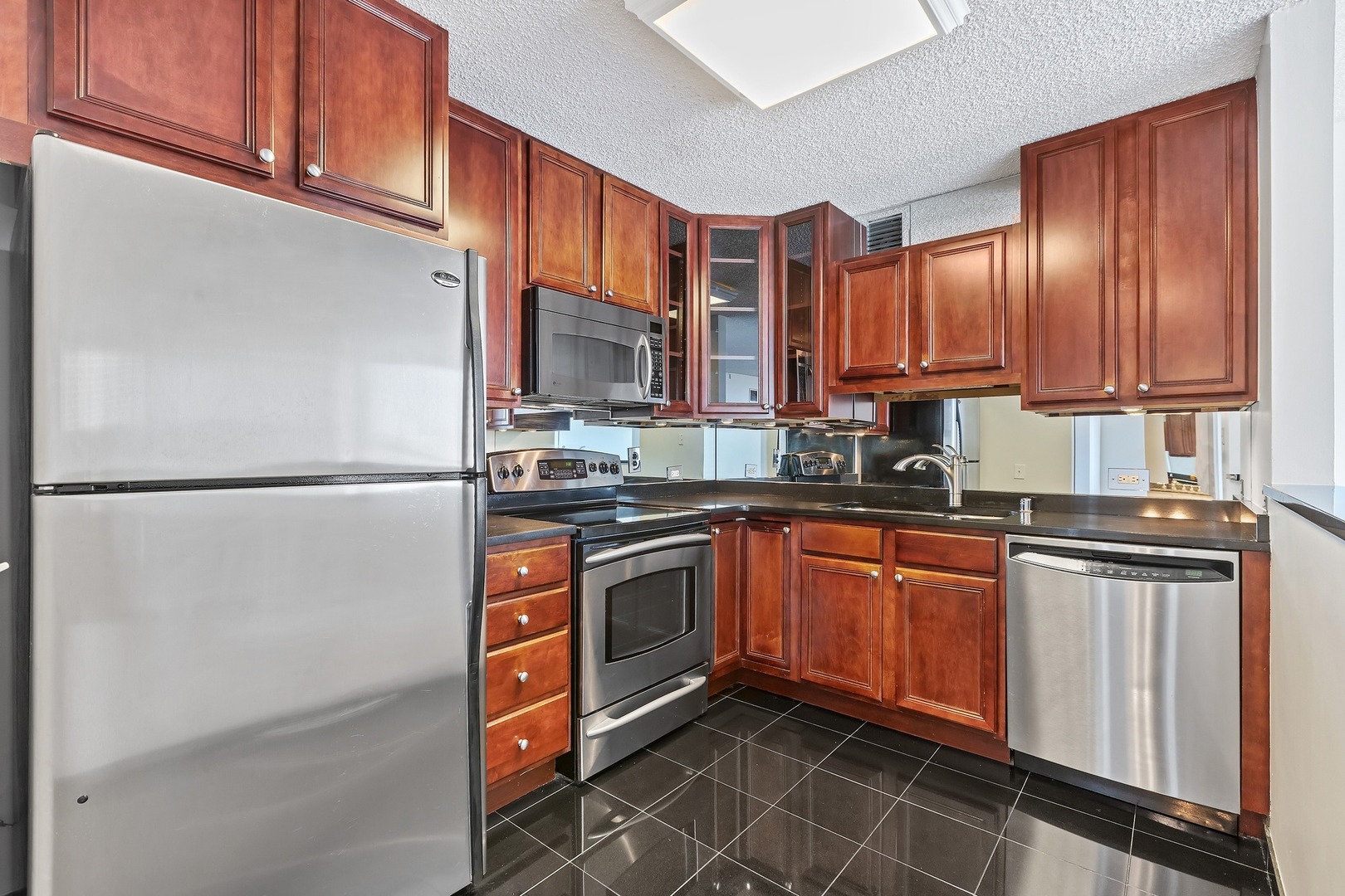 33 West Delaware Place, Unit 22H Chicago, IL 60610 - Photo 3 of 23 a kitchen with stainless steel appliances granite countertop a refrigerator a stove top oven a sink and dishwasher