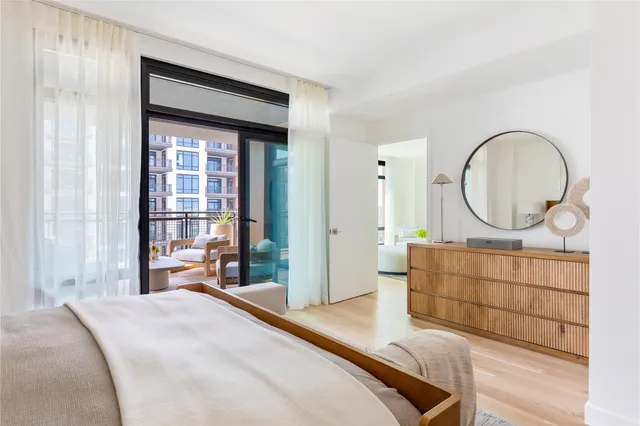 a bedroom with a bed mirror and a window