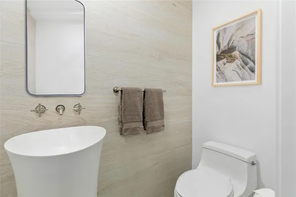 a bathroom with a toilet sink and mirror