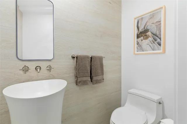 a bathroom with a toilet sink and mirror