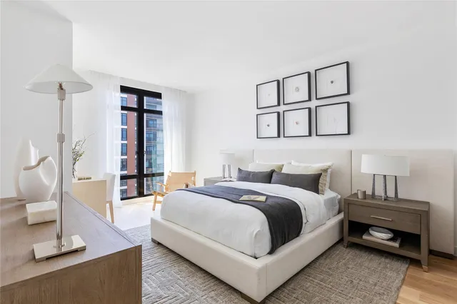 a bedroom with a bed a mirror and a window