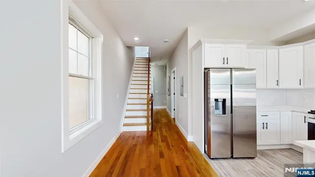 a view of a kitchen with wooden floor and electronic appliances