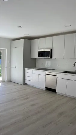 a view of a kitchen with a sink and a refrigerator