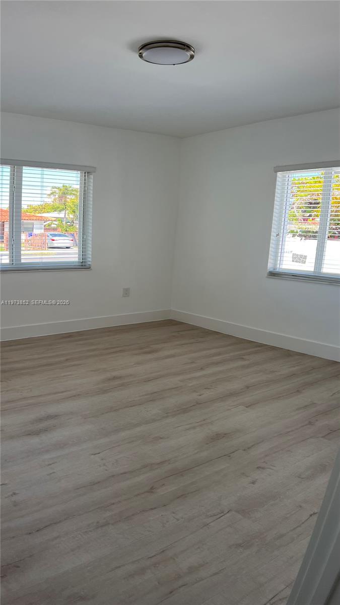 2800 Southwest 25th Street, Unit 1 Miami, FL 33133 - Photo 20 of 48 an empty room with wooden floor and windows