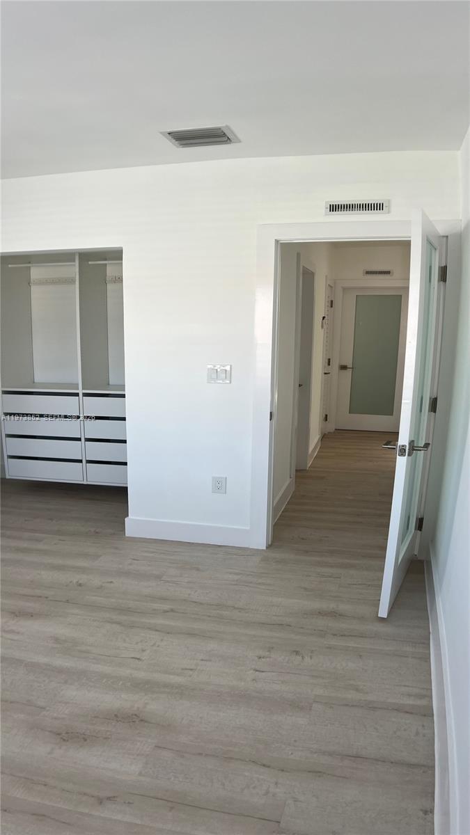 2800 Southwest 25th Street, Unit 1 Miami, FL 33133 - Photo 21 of 48 a view of room with stairs and wooden floor